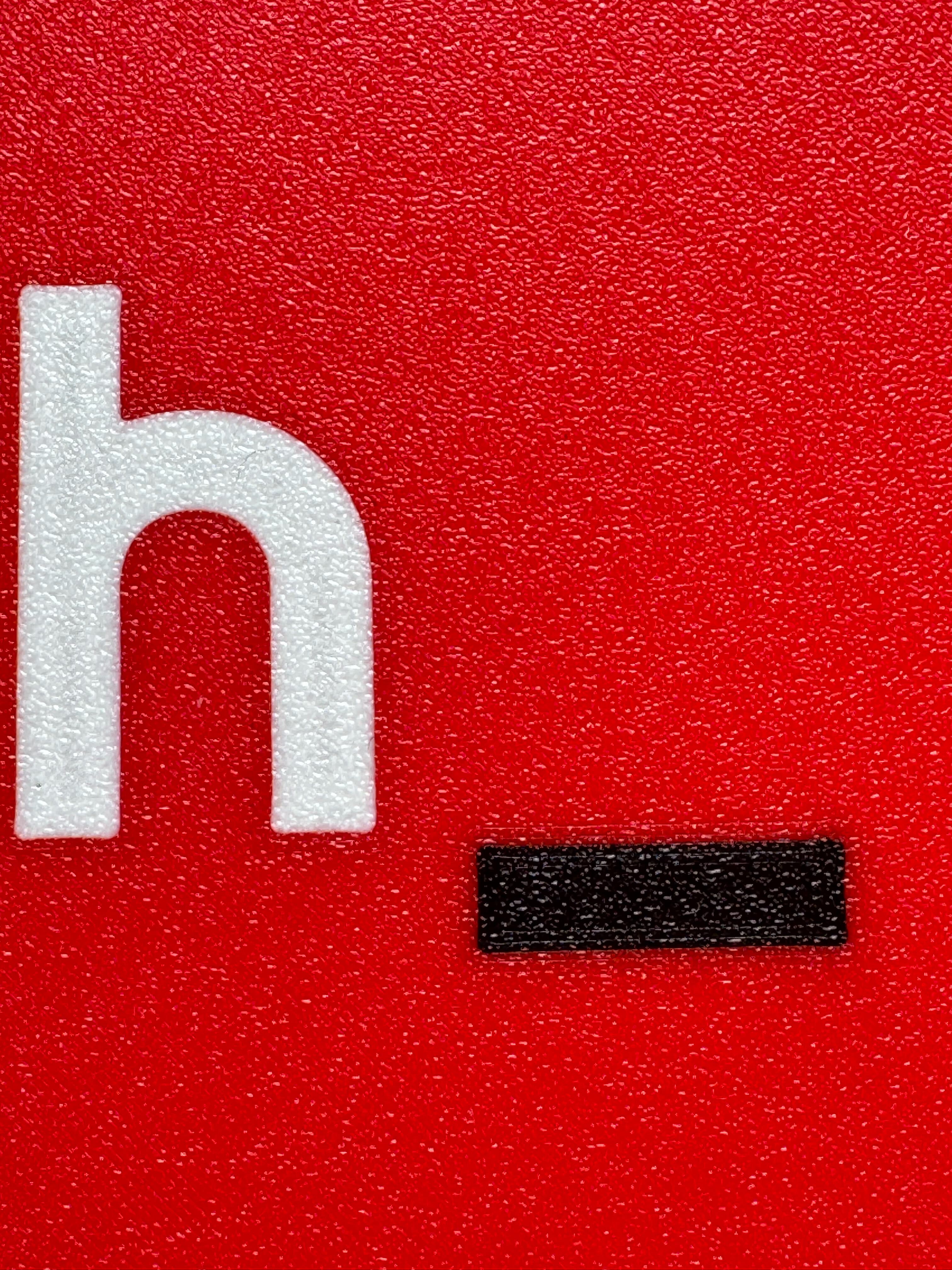Close-up of the letters and the red plate meeting in a clean, flush edge